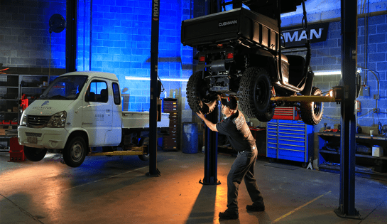 Werres technician working on a vehicle in a well-lit service garage with tools and equipment visible