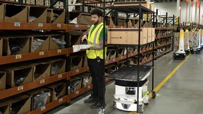 Warehouse robot assisting worker with order picking.